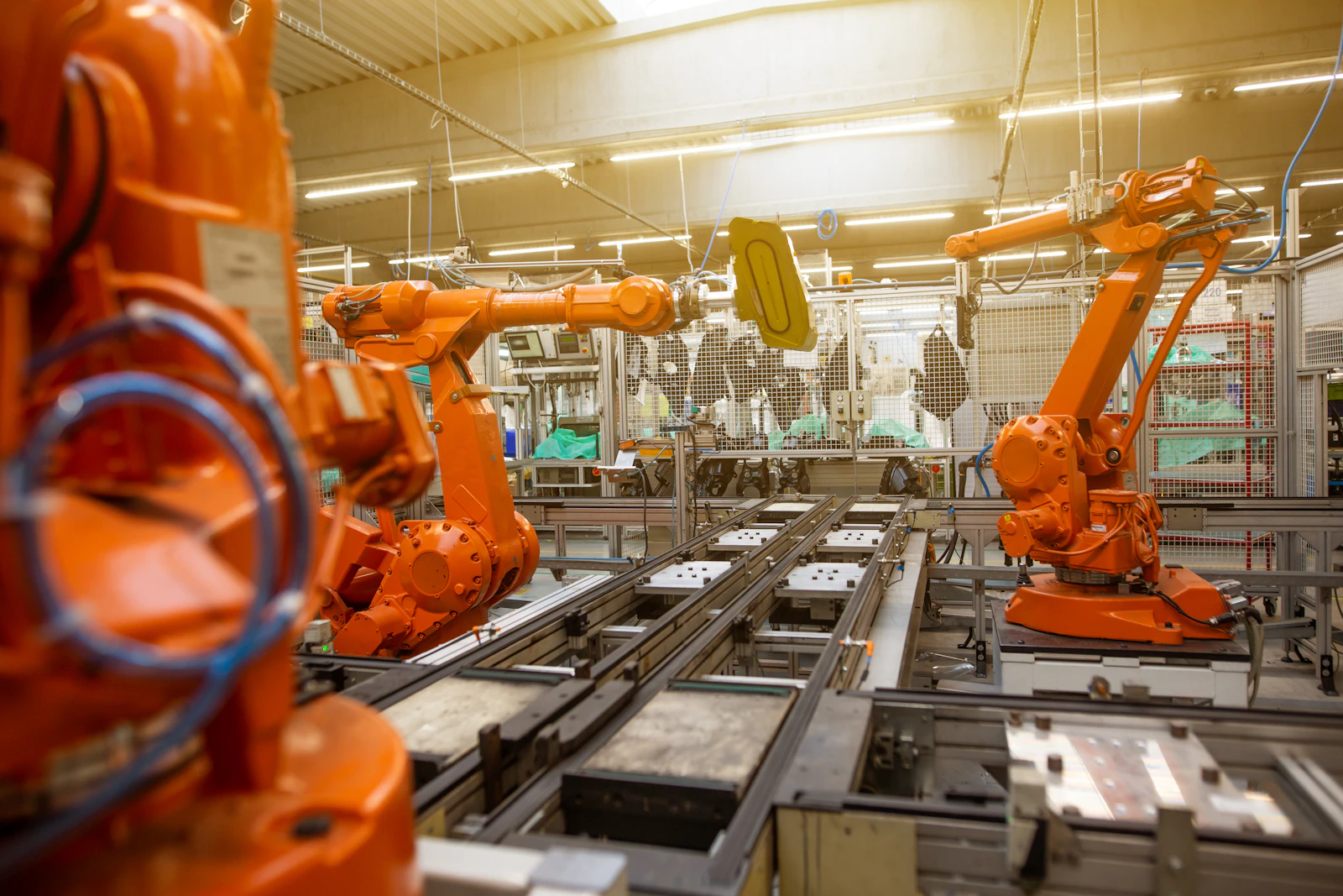 Brazos robóticos y equipos automatizados en una línea de producción industrial.